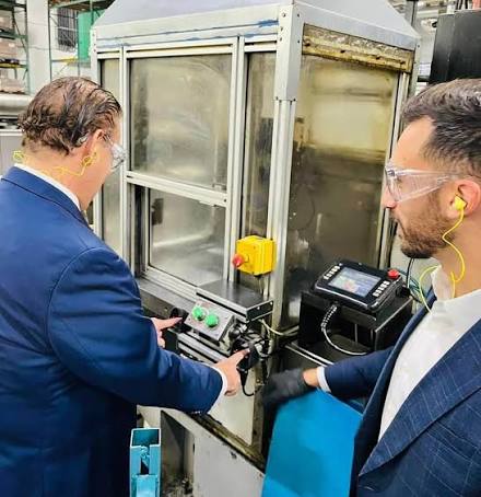 Engineers inspecting controls on specialized manufacturing equipment